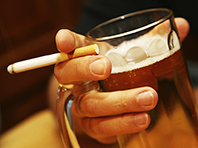 hand holding a cigarette and beer mug